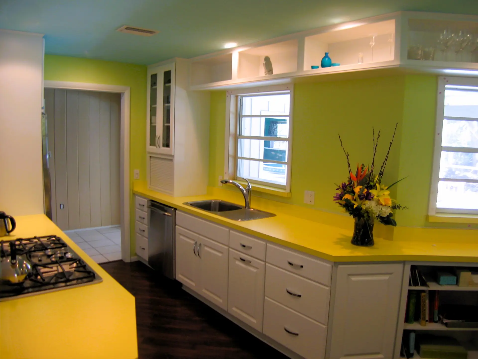 A wide shot of a bright, white kitchen remodel with a pop of yellow in a Sarasota historic home