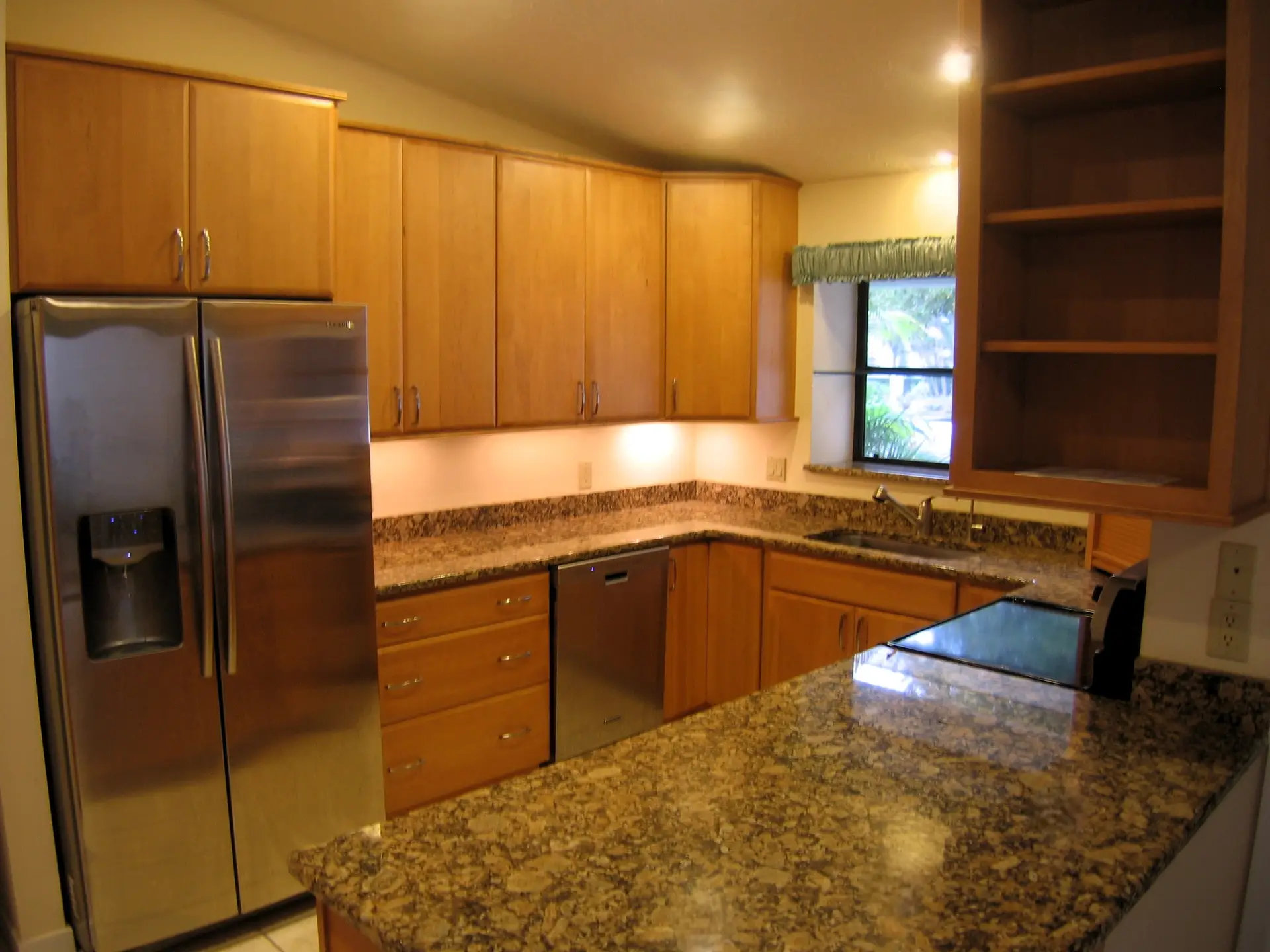Beautifully remodeled kitchen in Bradenton, FL with honey maple cabinets and Giallo Fiorito granite countertops