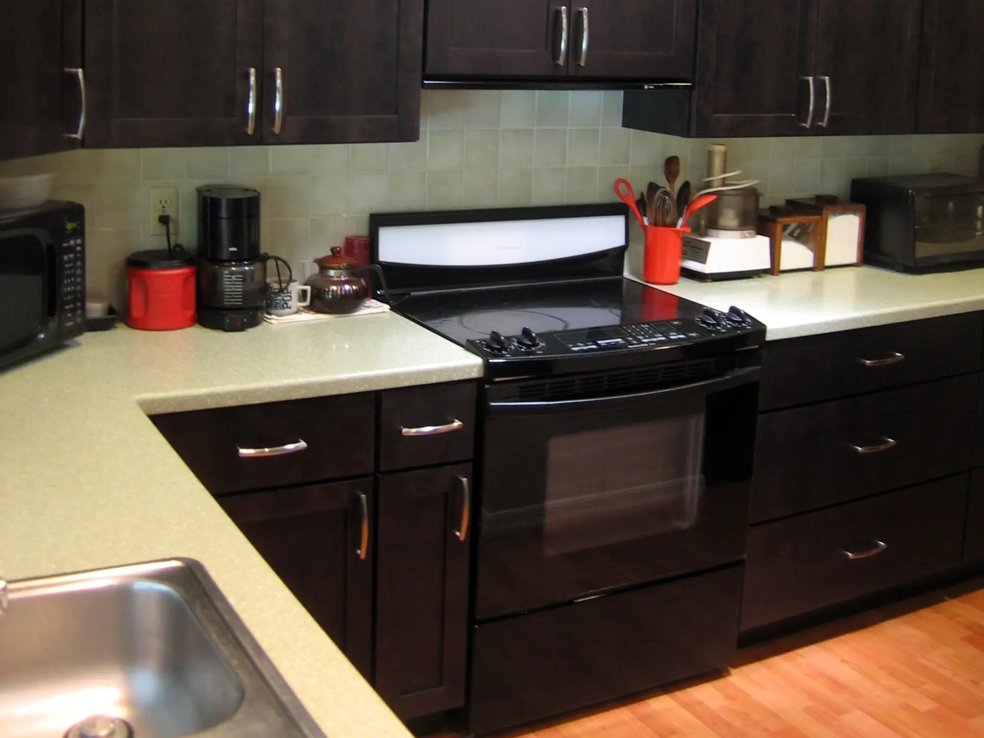 Close-up of a kitchen cabinet with a rich coffee stain on maple wood and a sleek Top Knobs pull