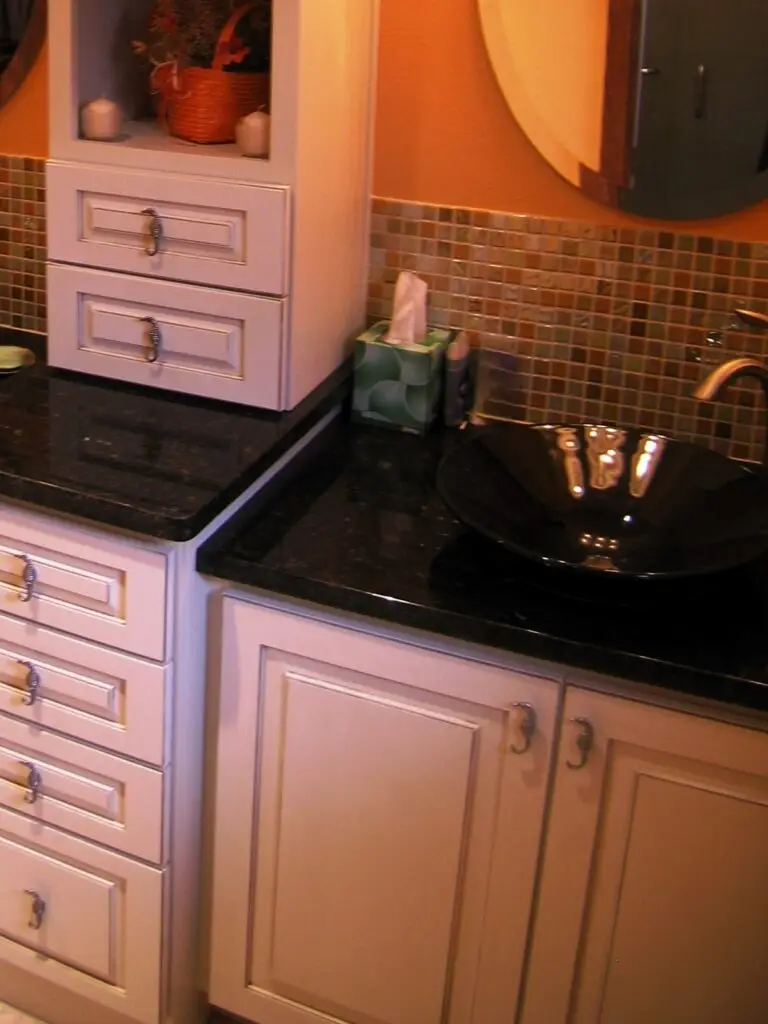 Custom StarMark cabinet storage with mosaic tile backsplash and decorative seahorse pulls