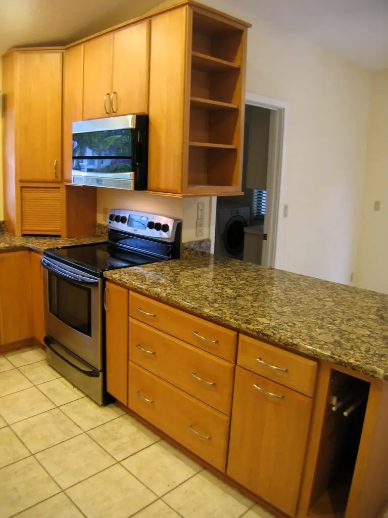 The peninsula and primary work space in this kitchen, housing not only valuable countertop area but a trash pull out and towel bar, conveniently located next to the range