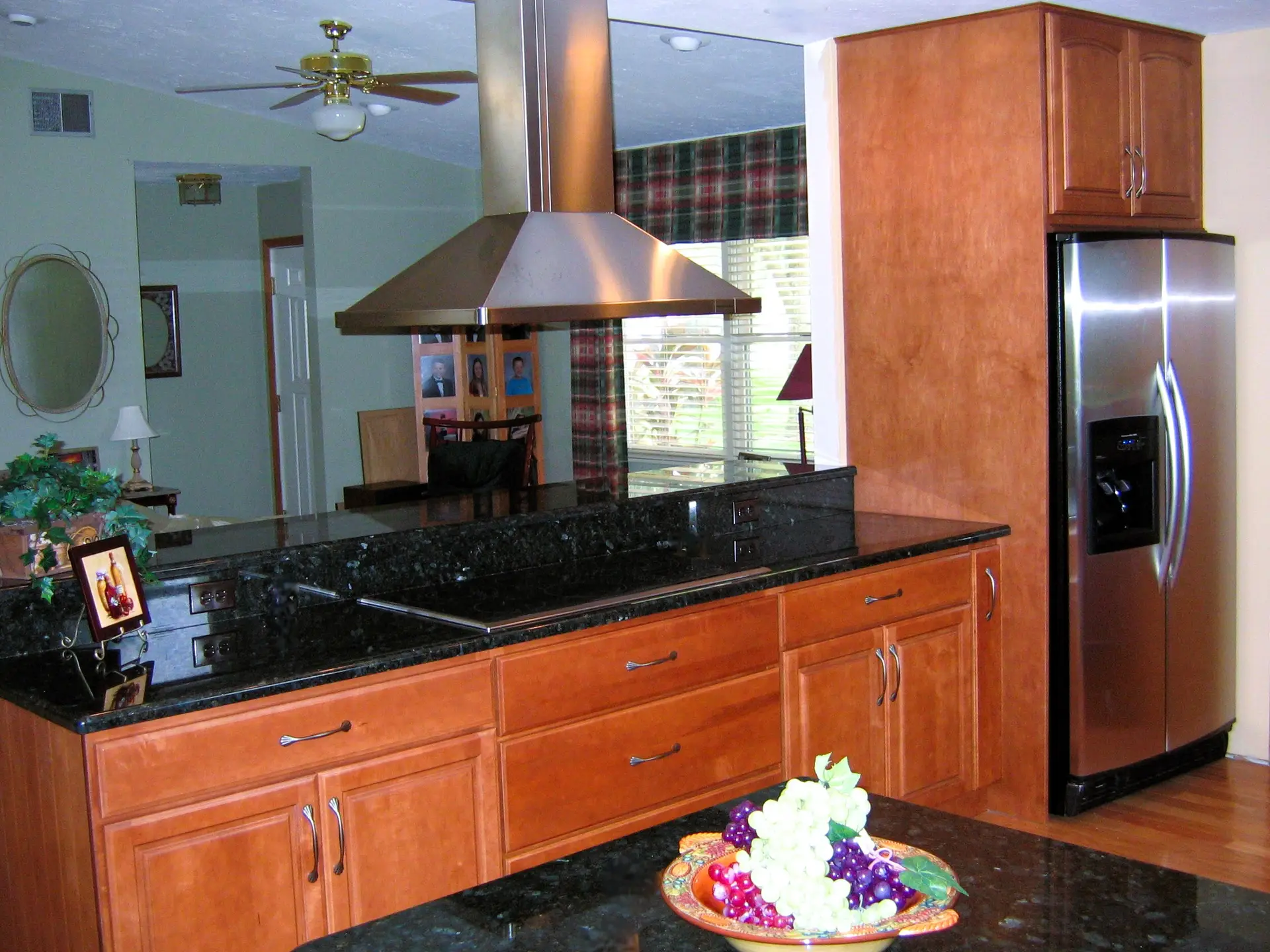 Detail shot of a professional grade Wolf cooktop and a modern chimney style island hood in a Palmetto kitchen remodel