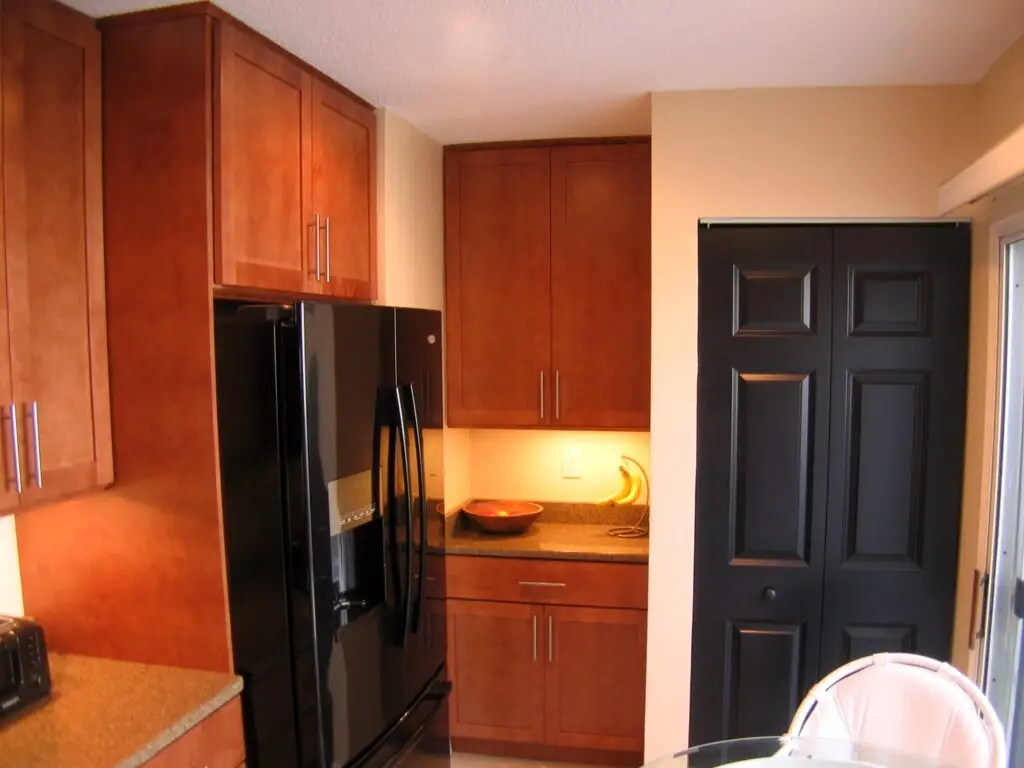 Modern kitchen with warm chestnut cabinetry and new counter space from laundry closet remodel in Bradenton condo