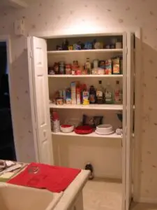 Before photo of a pantry with bifold doors and fixed shelves