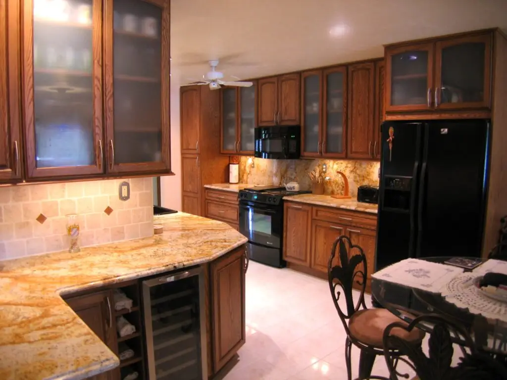 Entertaining zone wine fridge stemware storage StarMark oak cabinetry granite backsplash