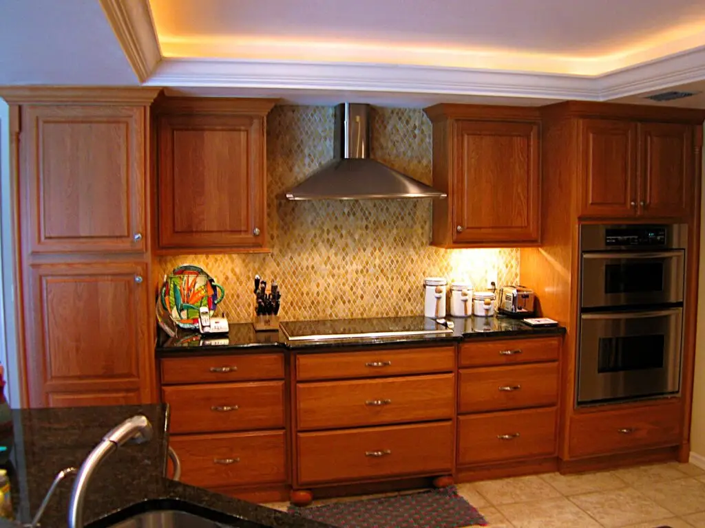 close up of kitchen cooktop with pantry and built in ovens