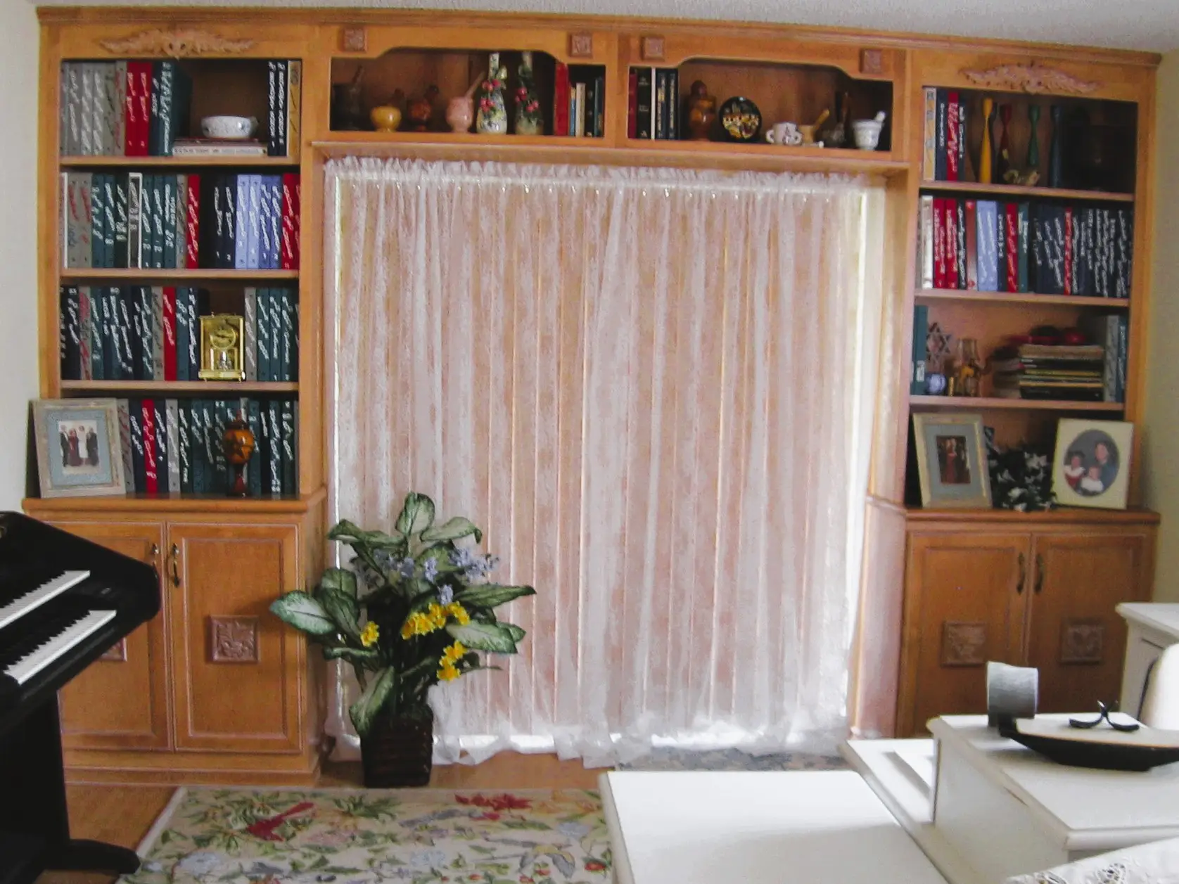 Custom bookshelves and storage framing a sliding glass door in a small condo living room
