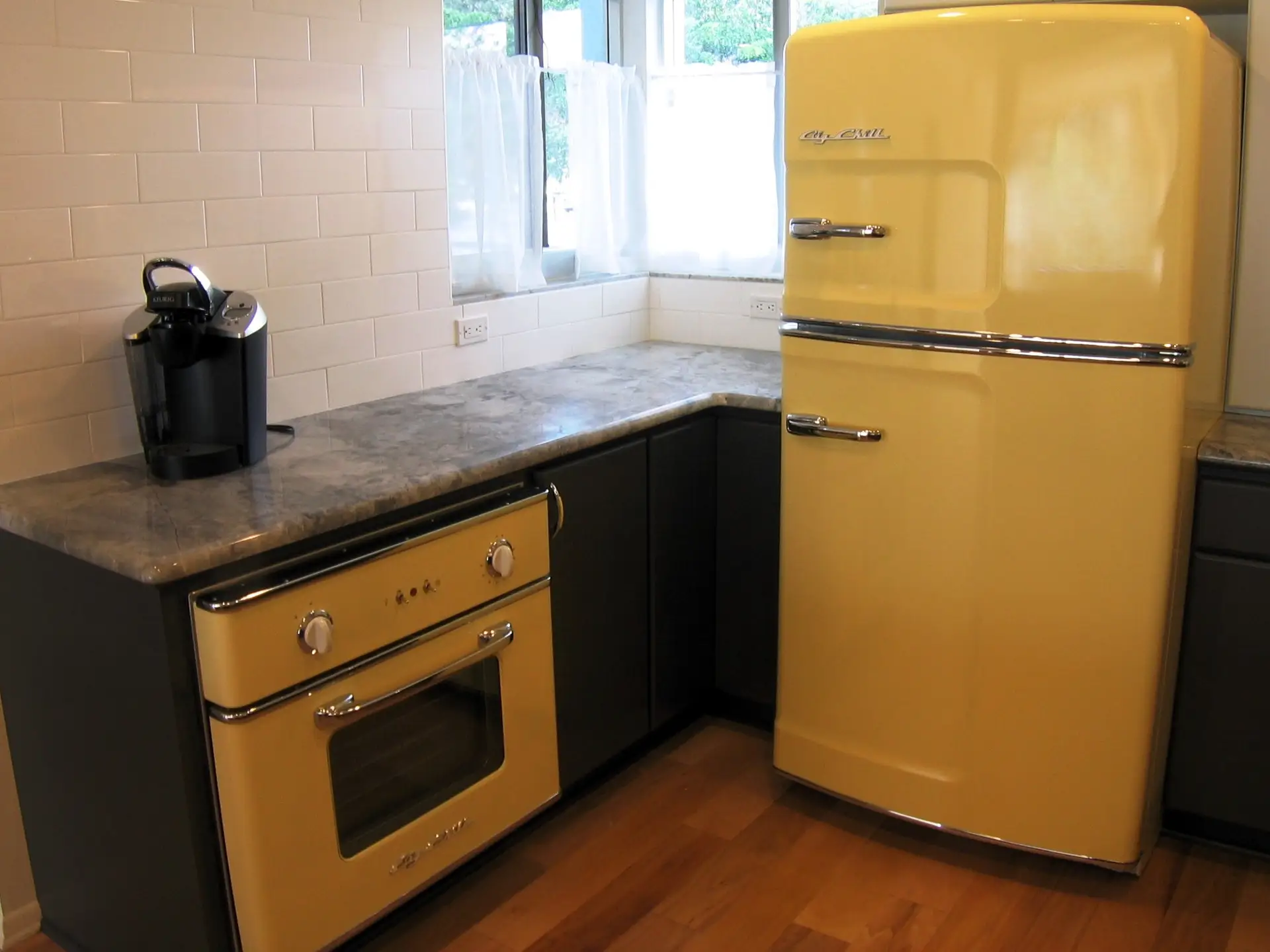 Big Chill Appliances in Buttercup Yellow, both the inspriation and the focal point of this mid century kitchen