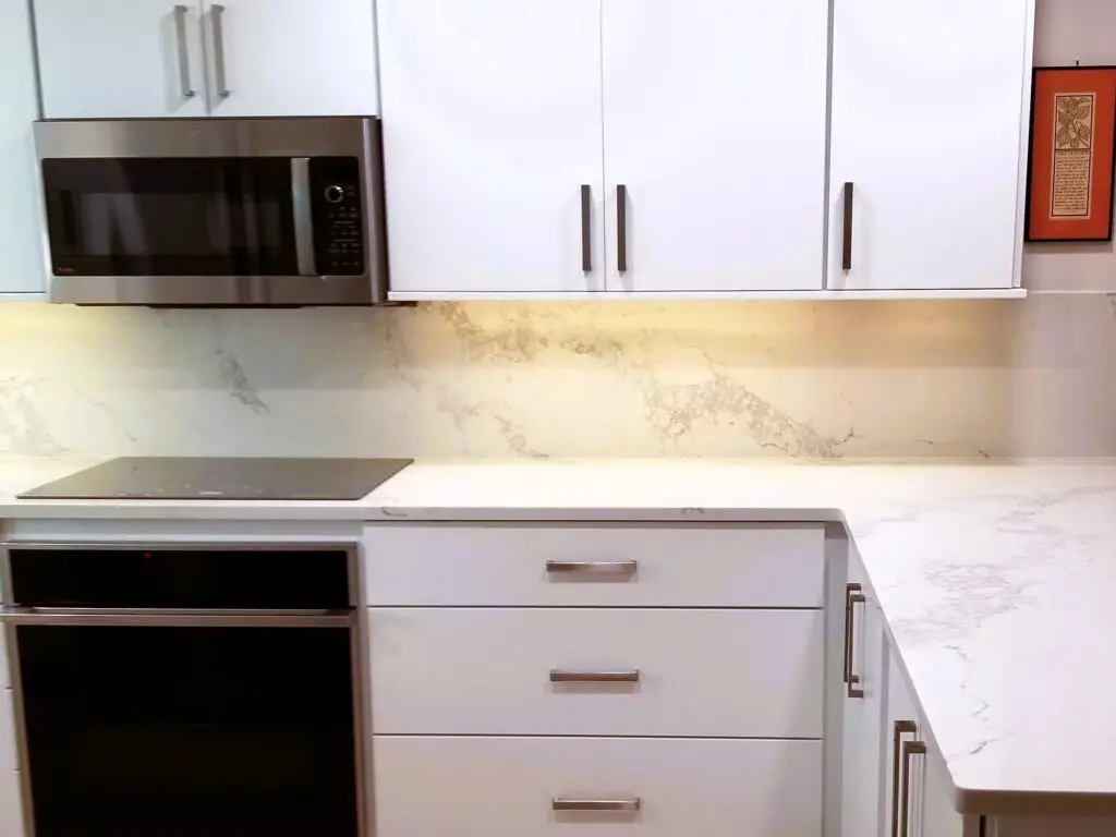 modern kitchen with white quartz countertops with full height backsplash and minimalist design