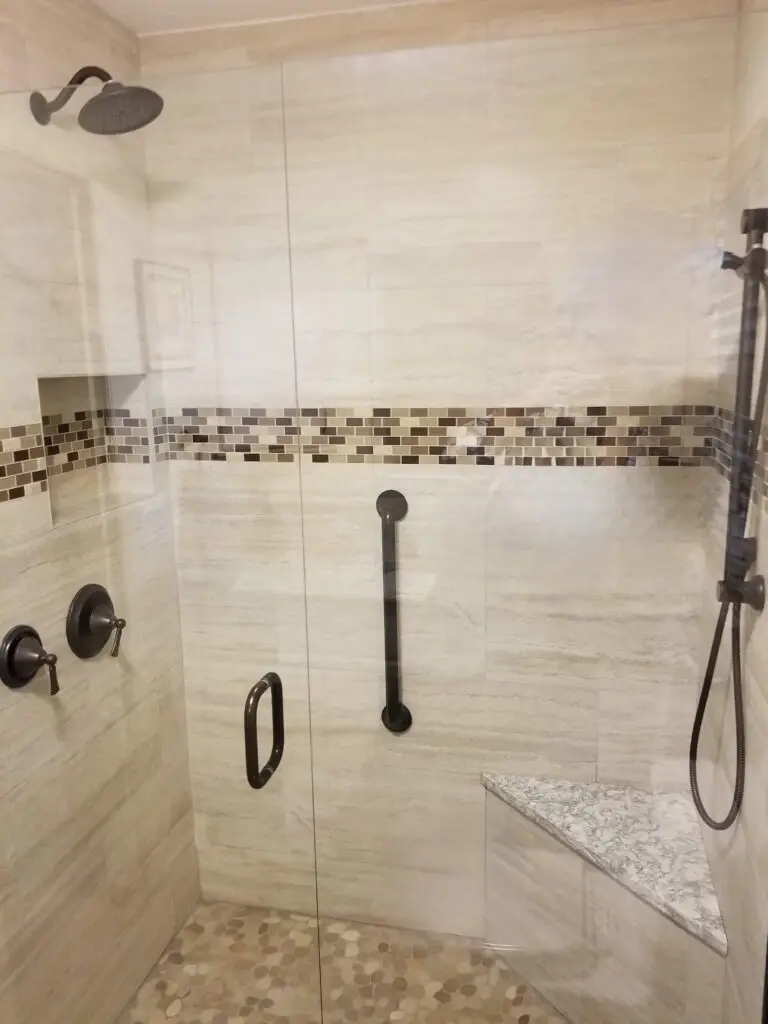 A clear, frameless glass shower enclosure in a small bathroom, making the space appear larger