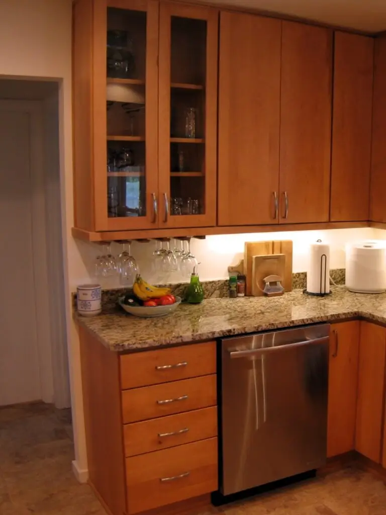 Glass display cabinets and a stemmed glass rack create an inviting focal point in this contemporary kitchen remodel