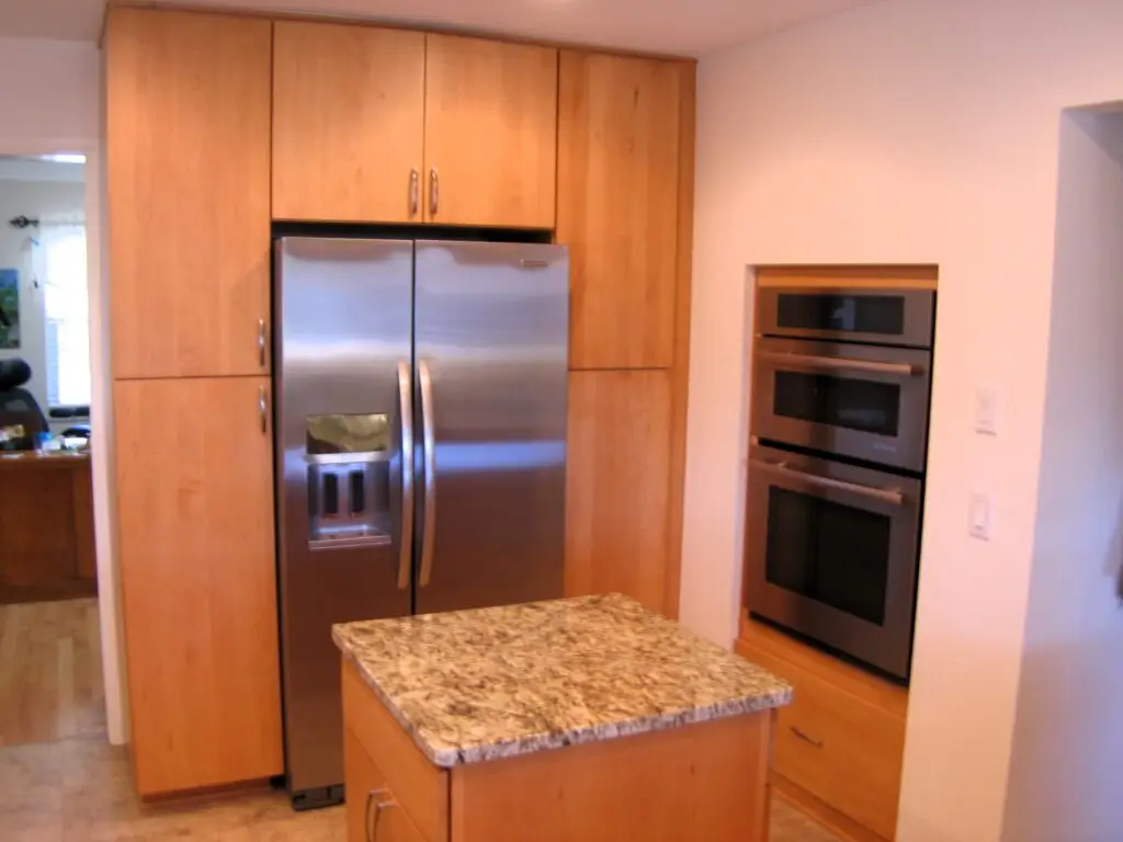 Pantry storage and built-in appliances add needed storage to this kitchen remodel after a wall was removed