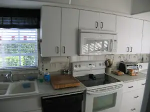 A before photo of a cold white kitchen without any thought to function.