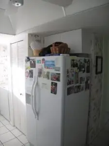 Before, the white refrigerator and pantry closet taking up visual space
