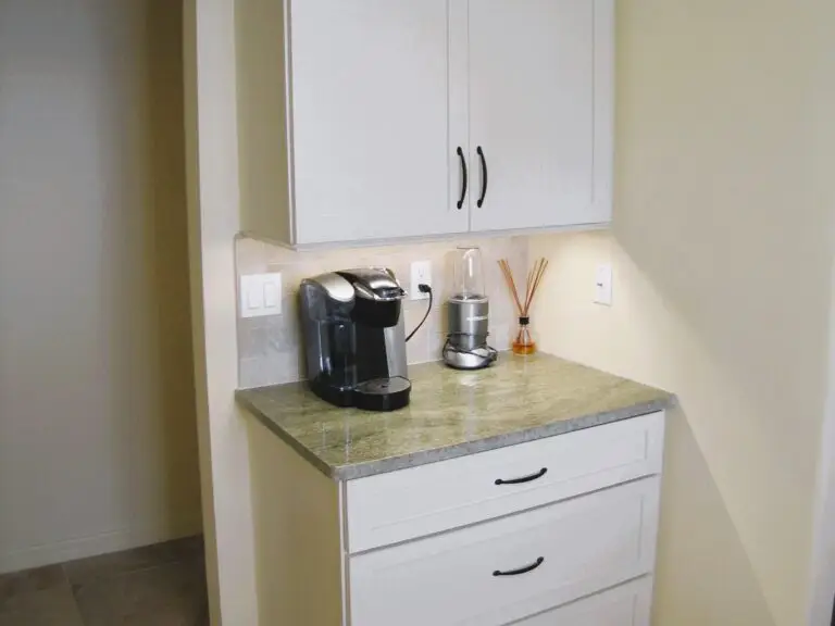 Space reclaimed from a hall closet made room for a coffee bar and serving area in Stressless Cabinetry's Simplicity doorstyle with an almond paint finish