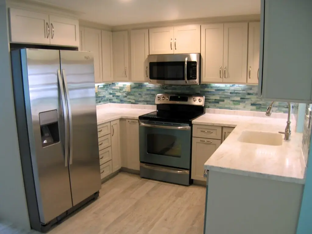 A modern kitchen with a stunning blue glass tile backsplash as the focal point