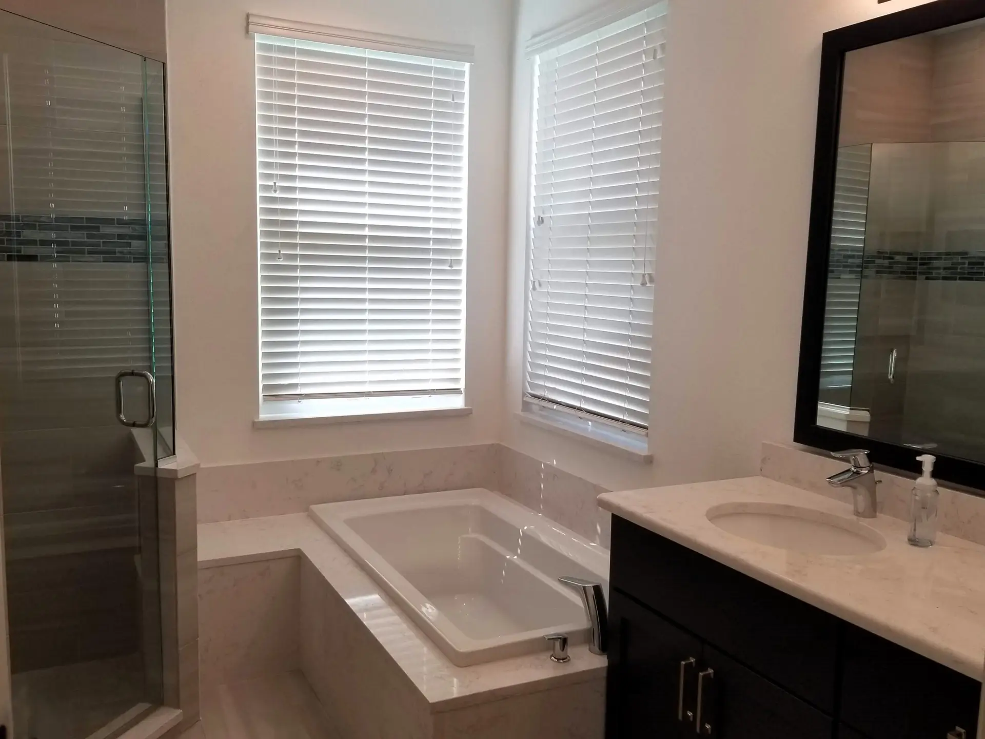 A remodeled master bath design featuring a platform tub and separate shower by Duncan's Creative Kitchens