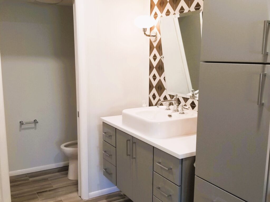 A close-up of a modern bathroom vanity featuring a high-contrast countertop, lever-style faucets, and a sleek design that is both stylish and accessible