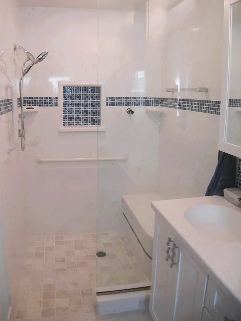 A modern, universally designed shower with a zero-entry, a comfortable built-in bench, and grab bars. The design prioritizes accessibility and safety for aging in place