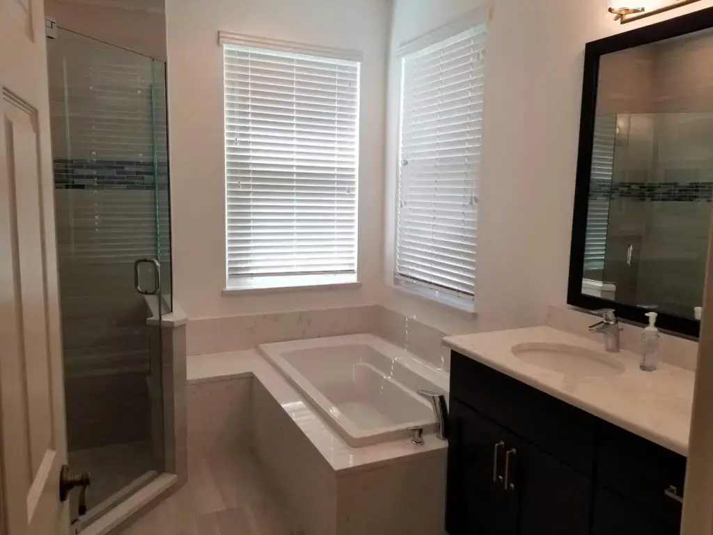 After photo of a newly remodeled Greenfield Plantation master bath with a navy blue vanity