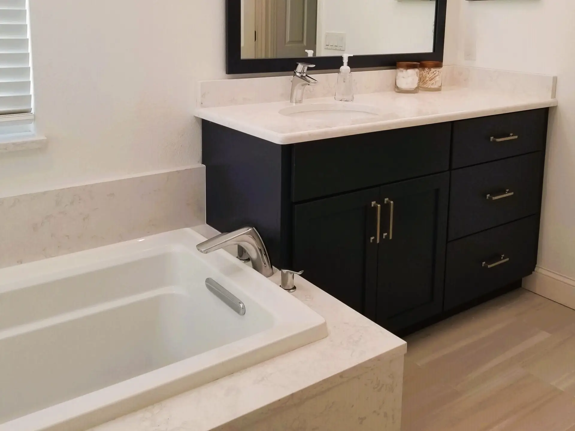 Close-up of a StarMark Cabinetry vanity and Kohler soaking tub with Cambria Torquay counters