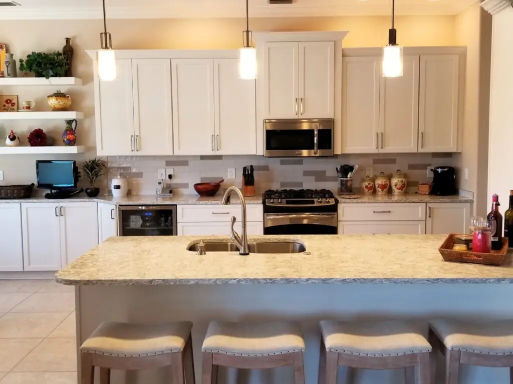 A bright, modern kitchen with white cabinets, a large island, and natural light, showing the possibilities of a kitchen remodel