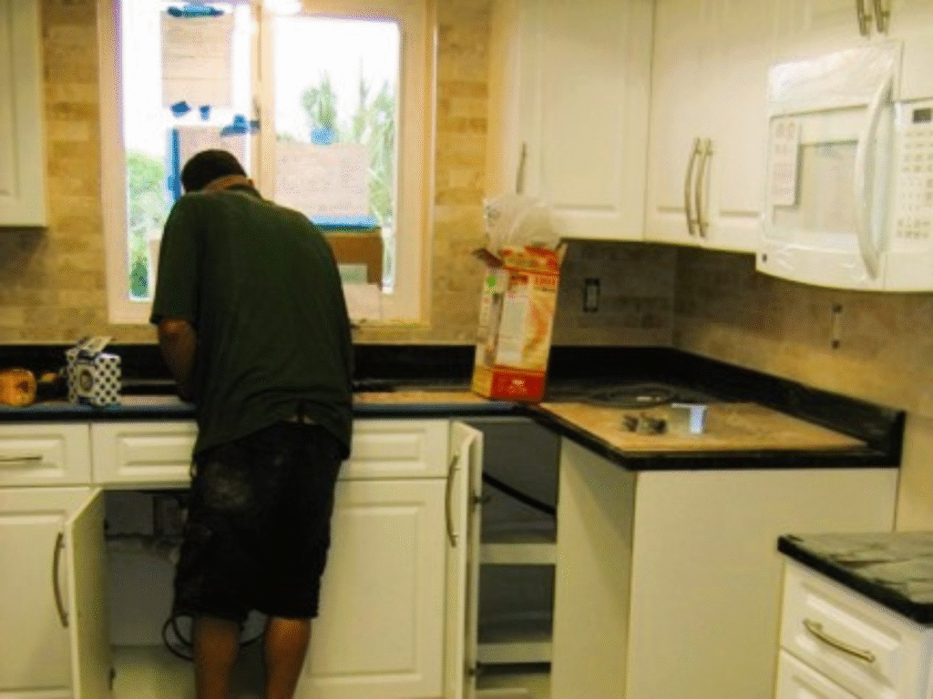 A building permit for a kitchen remodel is displayed prominently in the window at a construction site
