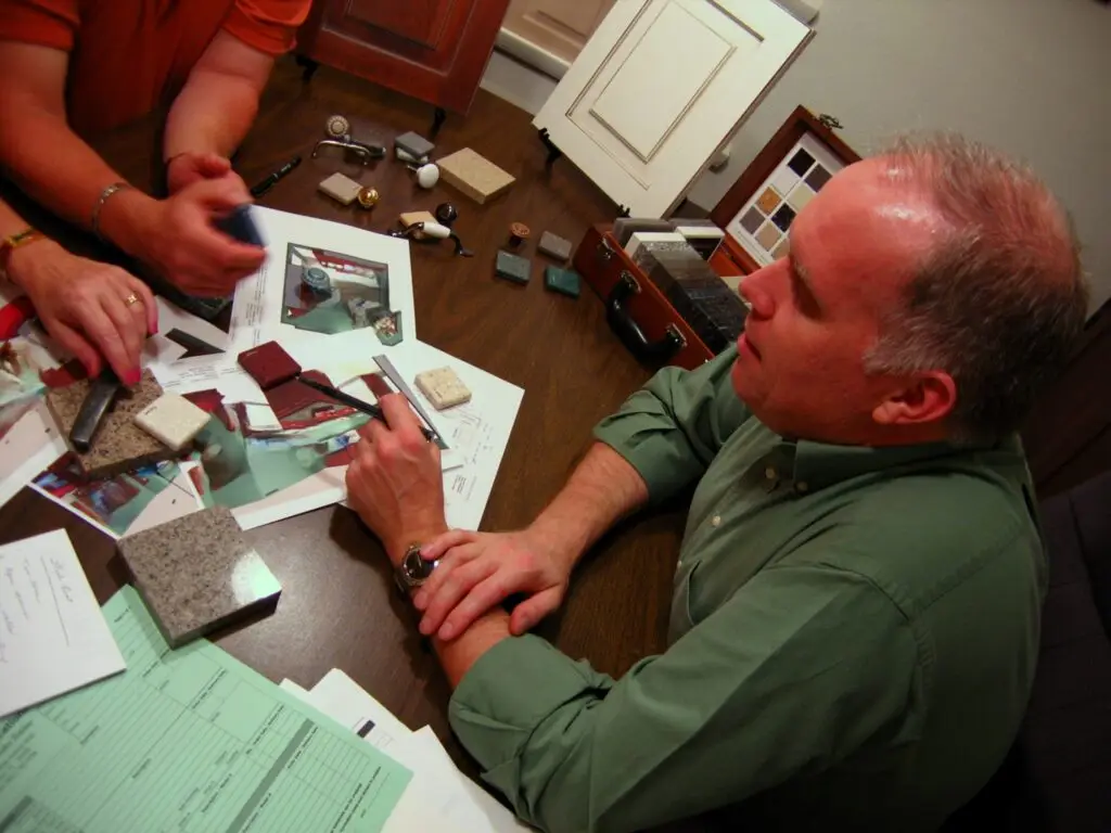 A professional kitchen designer from Duncans Creative Kitchens discussing budget friendly options with a homeowner