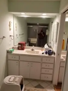 Before photo of the original master bathroom vanity with soffits and traditional tile