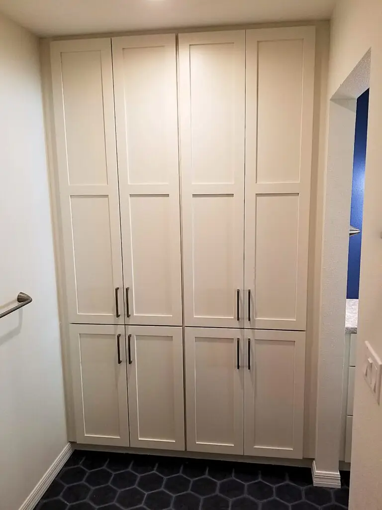 Custom white linen storage cabinets from StarMark provide ample storage in a renovated Bradenton master bathroom