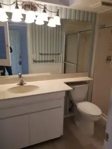 Hall bath vanity with blue striped wallpaper