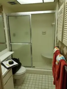 Hall bathroom shower with obscure glass and tall curb