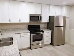 Image of newly installed white mantra cabinets and granite countertops