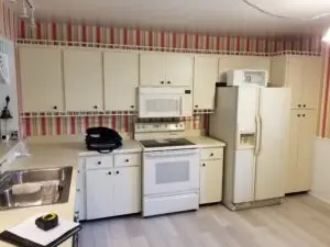 Image of ornate and dated Bradenton condo kitchen with striped wallpaper