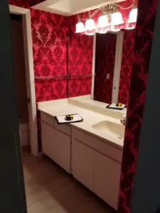 Master bath vanity with red flocked wallpaper