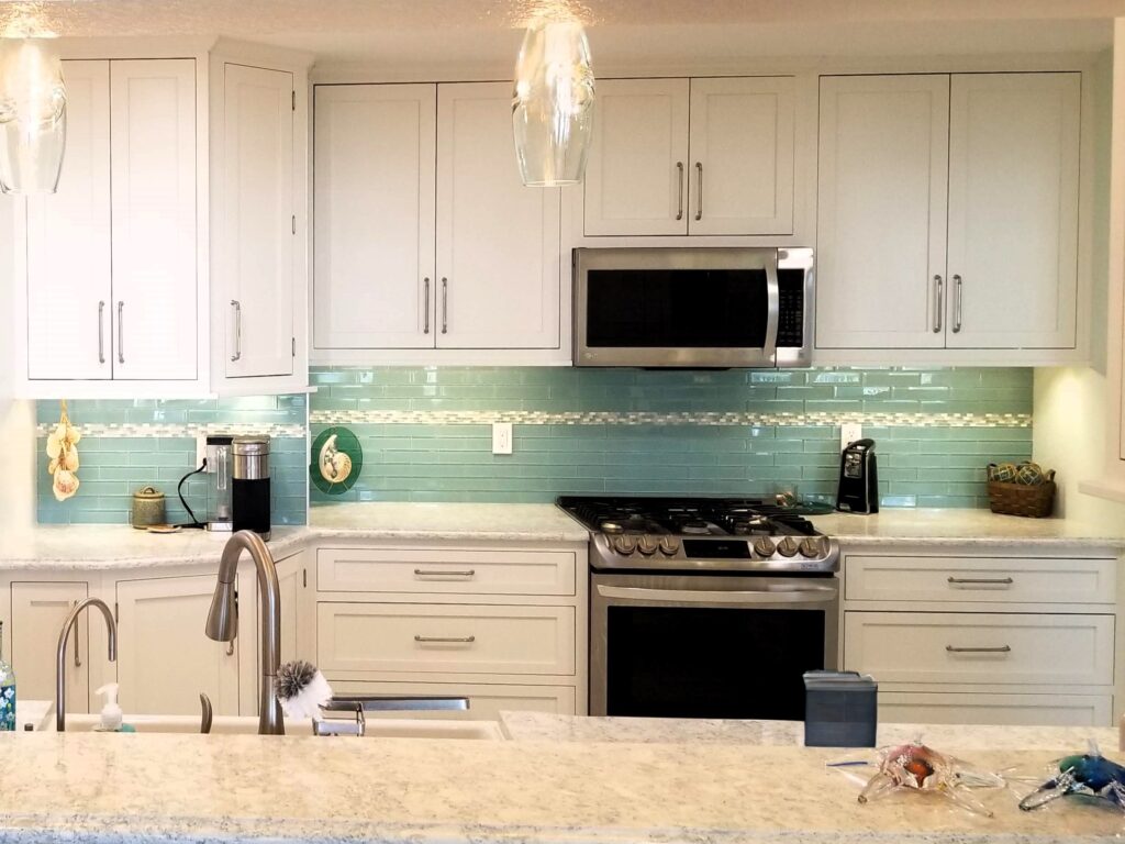Modern kitchen remodel with white cabinets and seafoam tile