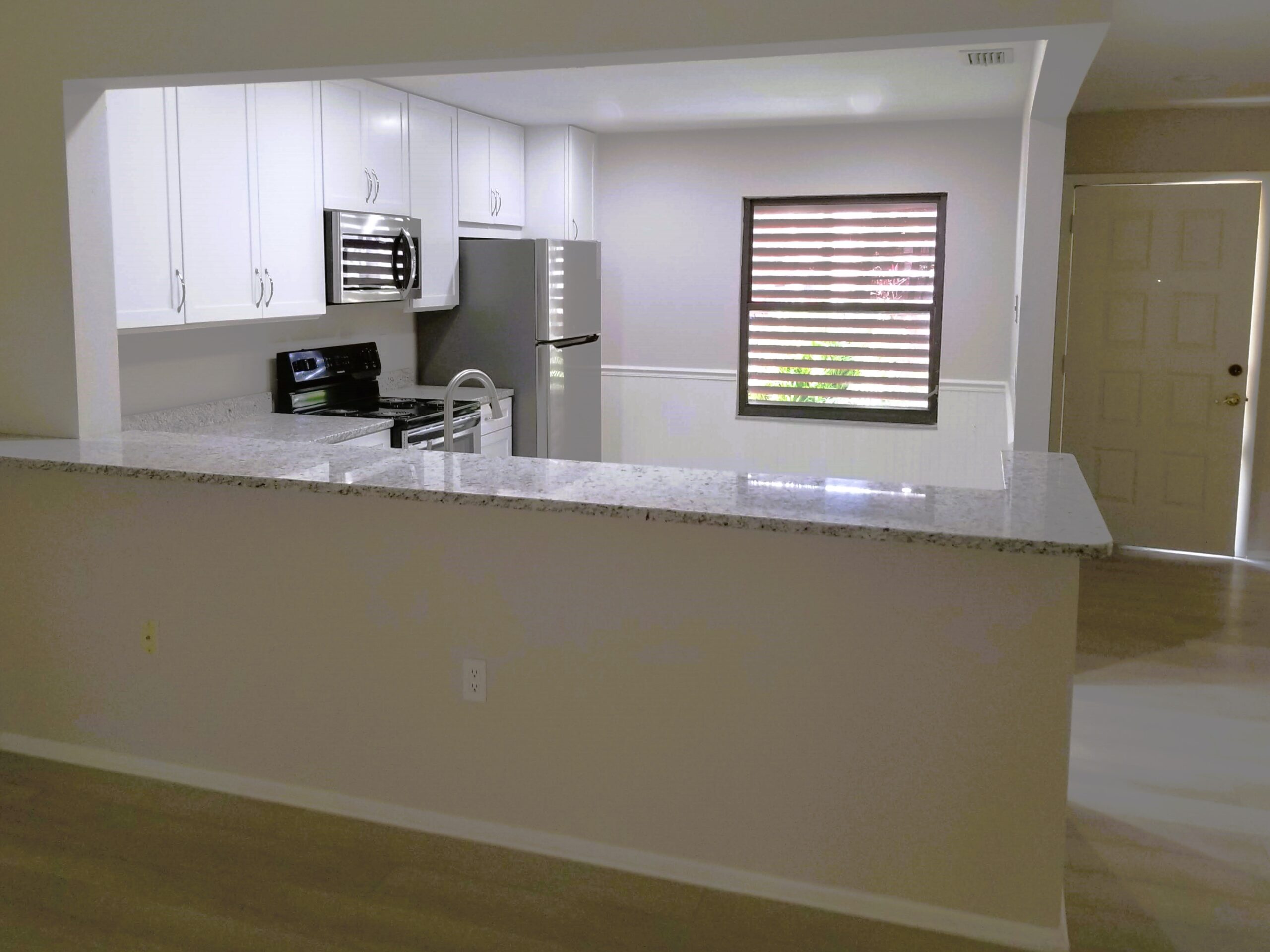 Spring Lakes condo kitchen after remodel with white Mantra cabinets