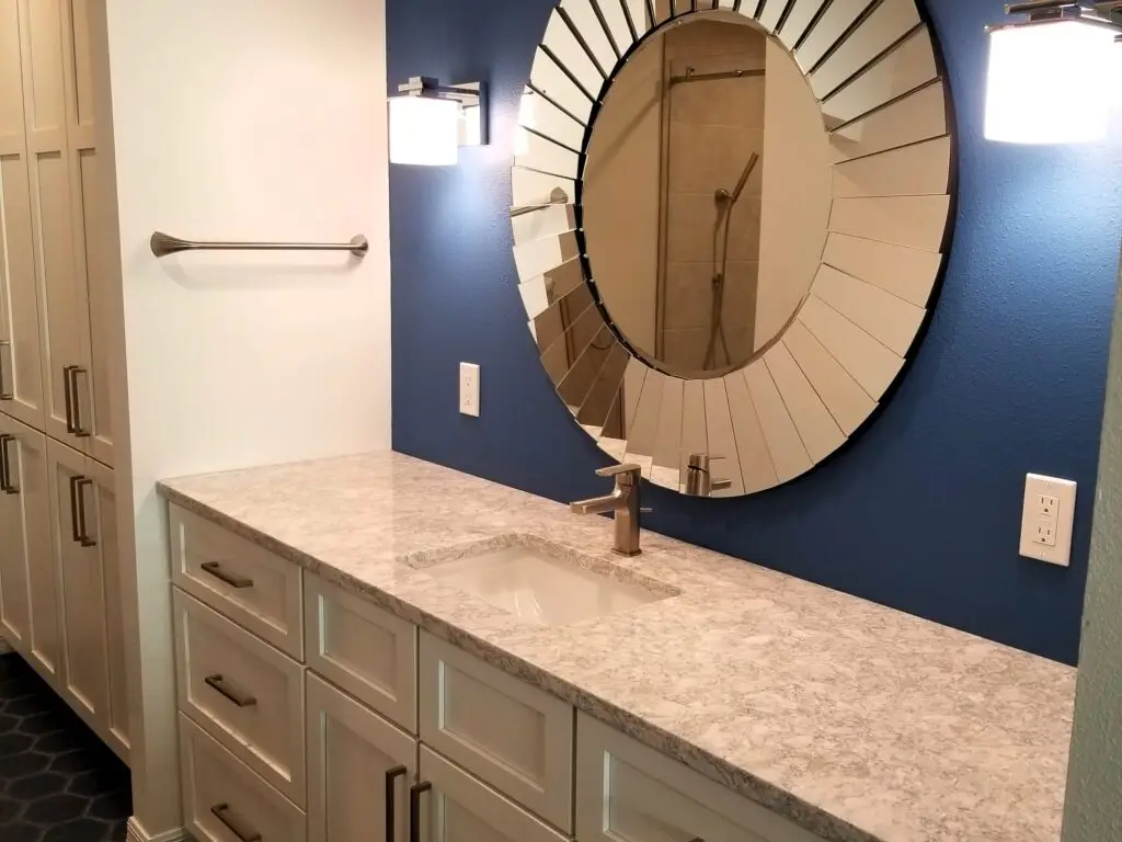 Vanity with sunburst mirror and royal blue accent wall