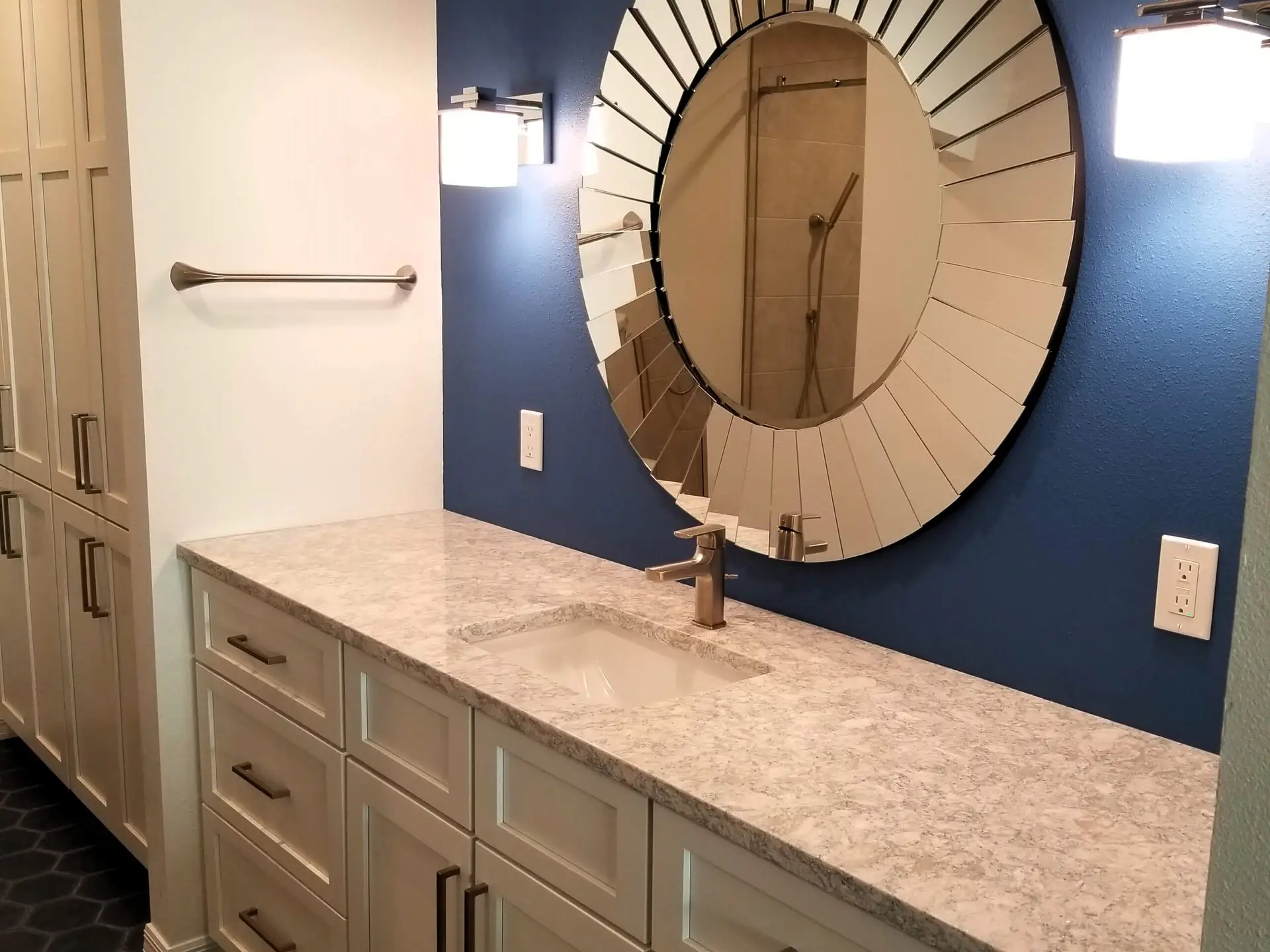 Vanity with sunburst mirror and royal blue accent wall