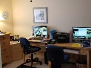 Old dual desk setup with oak furniture and limited workspace