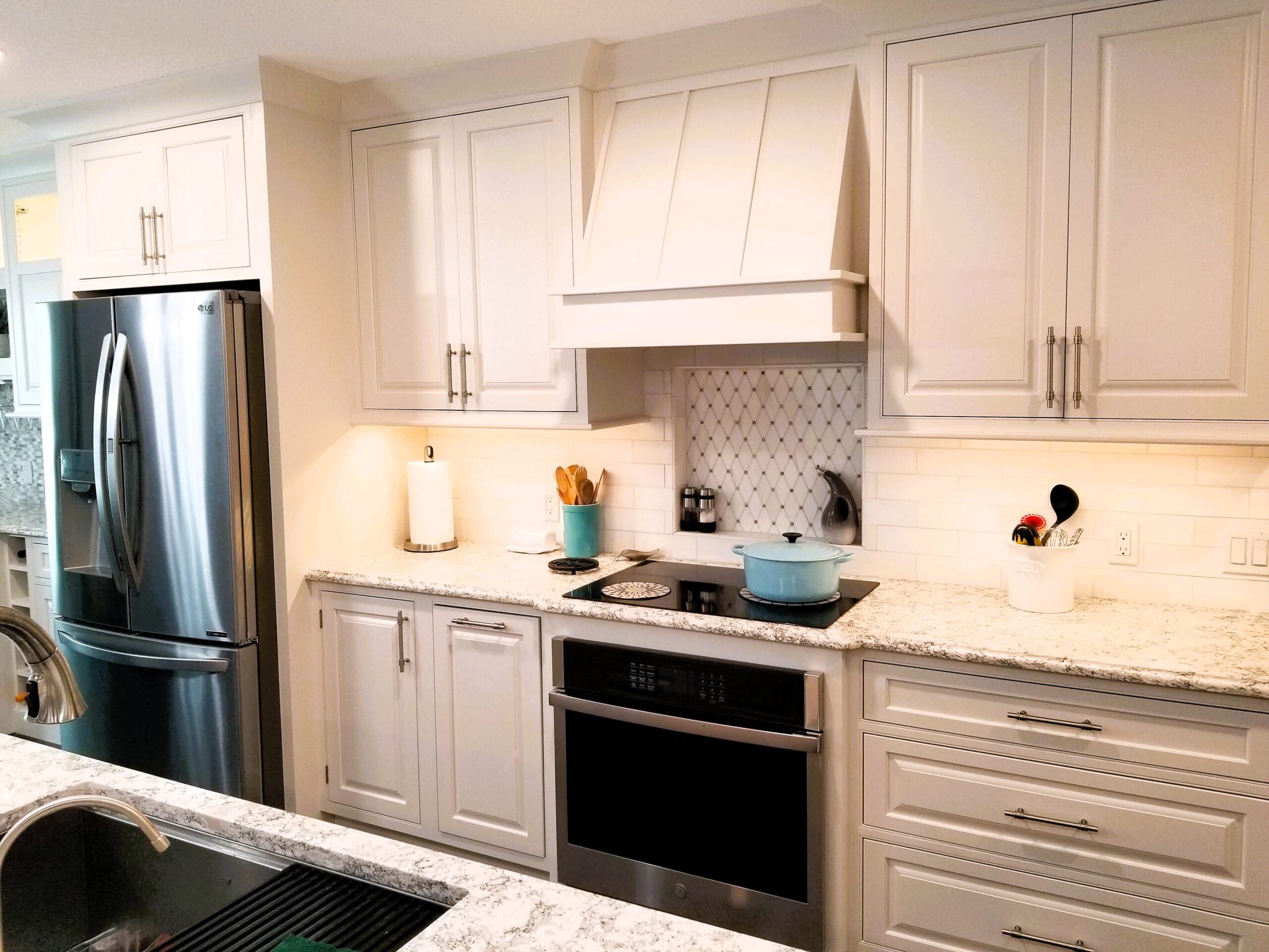 StarMark inset cabinets with integrated wood hood and induction cooktop in Palmetto kitchen