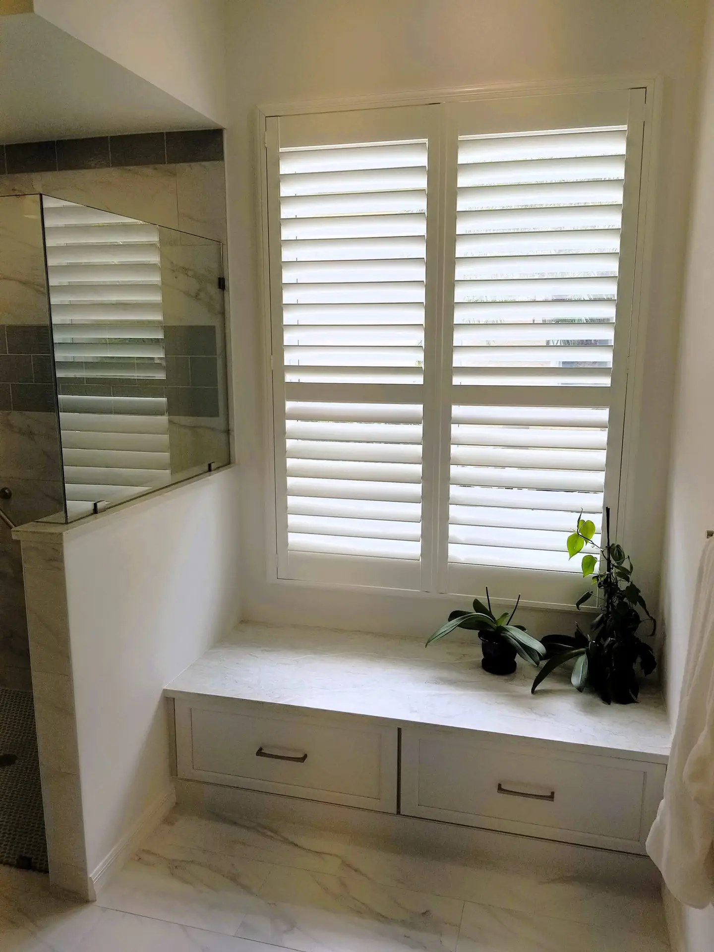 White window seat with drawers and a Pompeii Coastal countertop replacing a bathtub