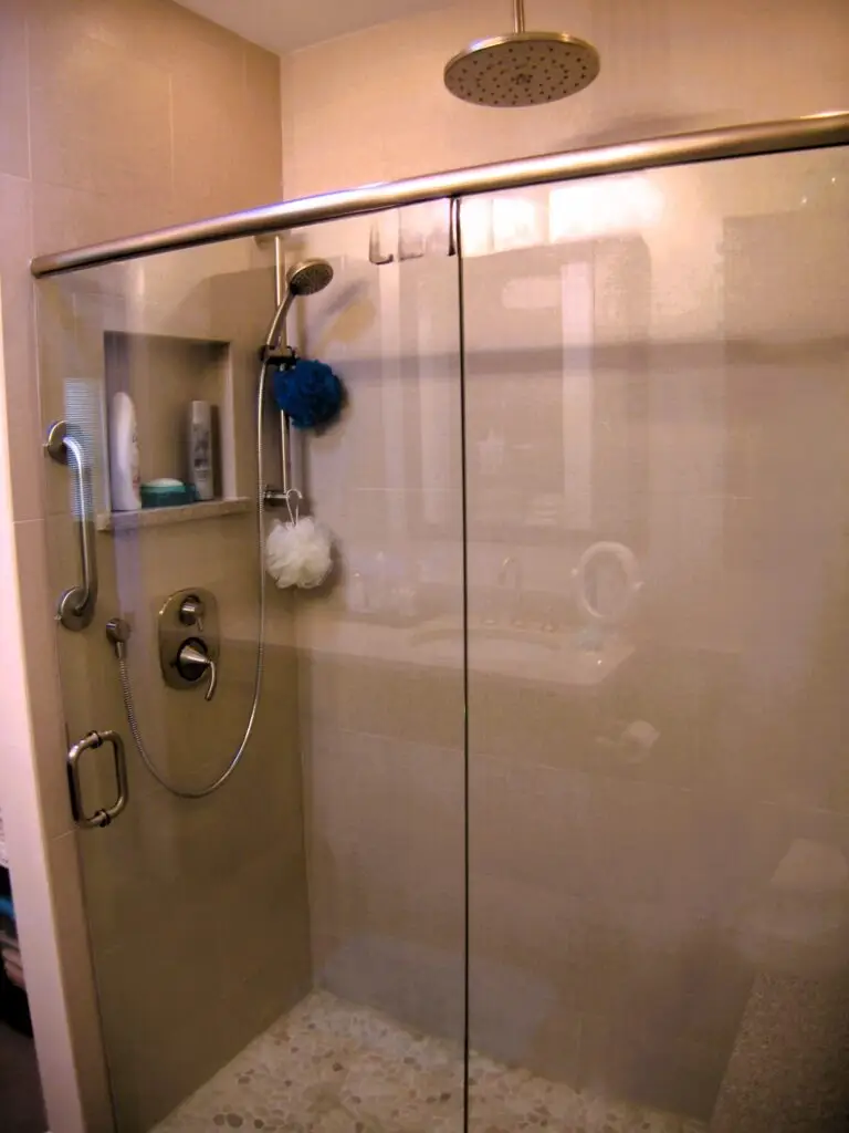 Close up of curbless shower in Bradenton aging in place bathroom with rainhead and built in bench