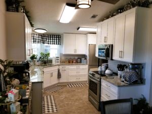 Finished mobile home kitchen remodel in Colony Cove with white cabinetry and granite countertops