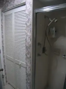 Linen closet and inefficient shower before a master bath remodel in Bradenton Florida