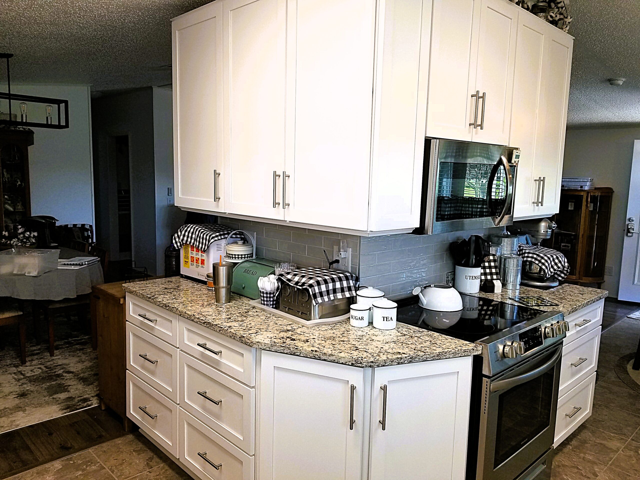 White shaker cabinets with deep storage drawers and stainless steel stove in a remodeled kitchen
