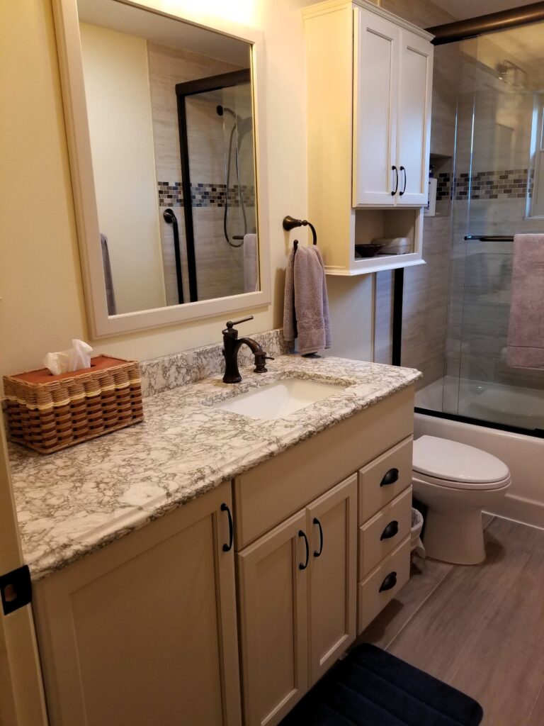 Bradenton bathroom remodel featuring StarMark cabinetry in Mushroom finish and corner storage cabinets