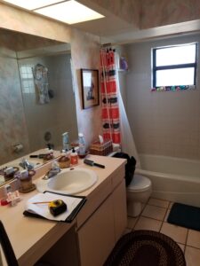 before photo of a cluttered and outdated vanity