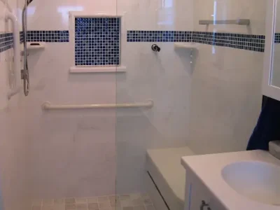 walk in shower with blue accents and built in seat in a custom bathroom remodeling project in Sarasota, Florida